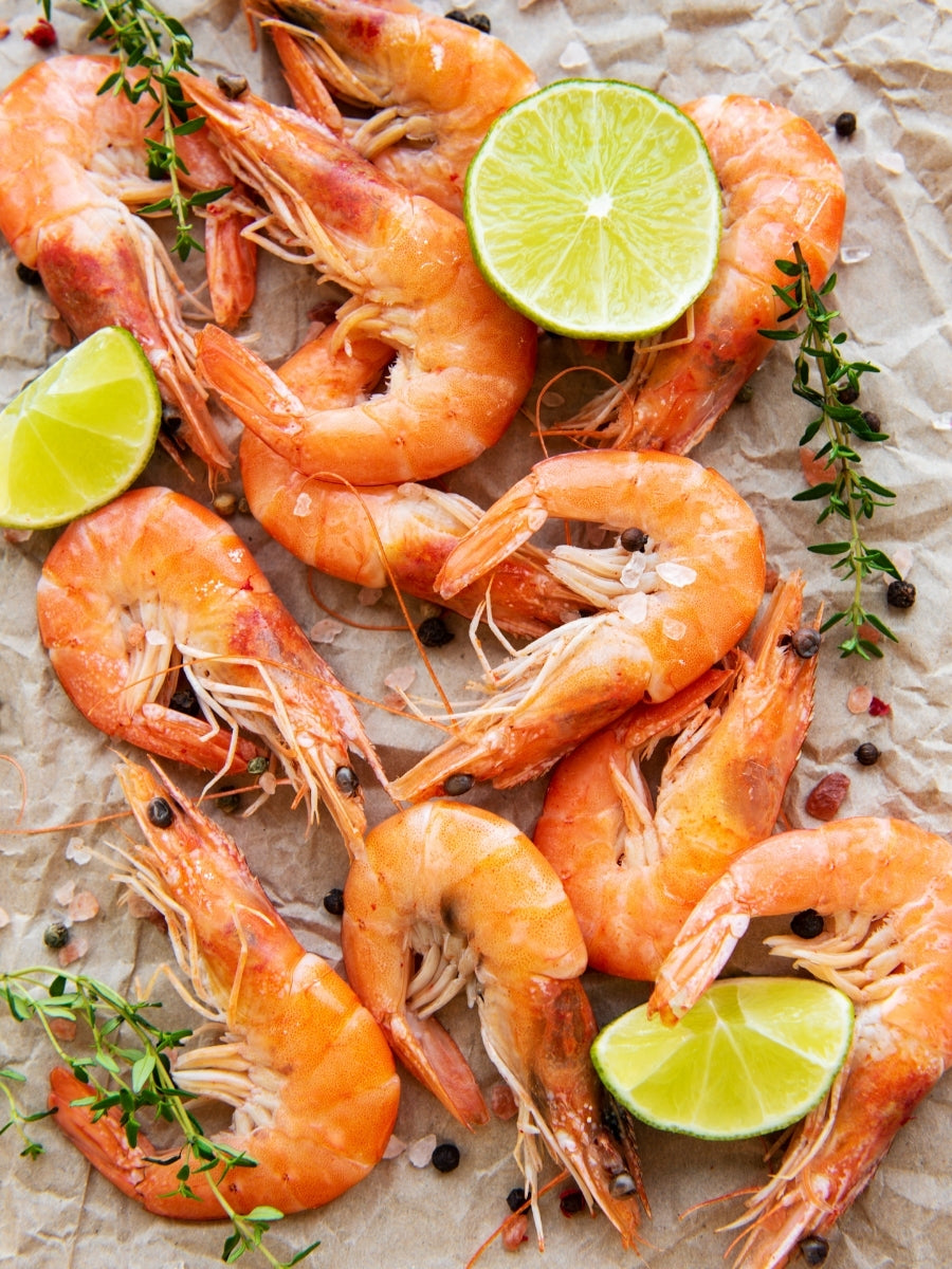 Whole head-on cooked shrimp with limes and spices