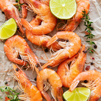 Whole head-on cooked shrimp with limes and spices